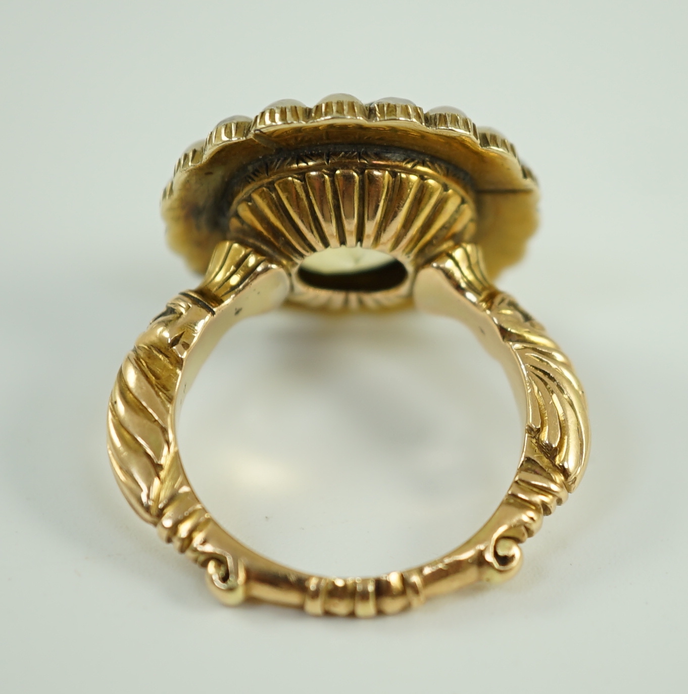 A 19th century style gold and round cut single stone yellow sapphire set dress ring, with split pearl set border